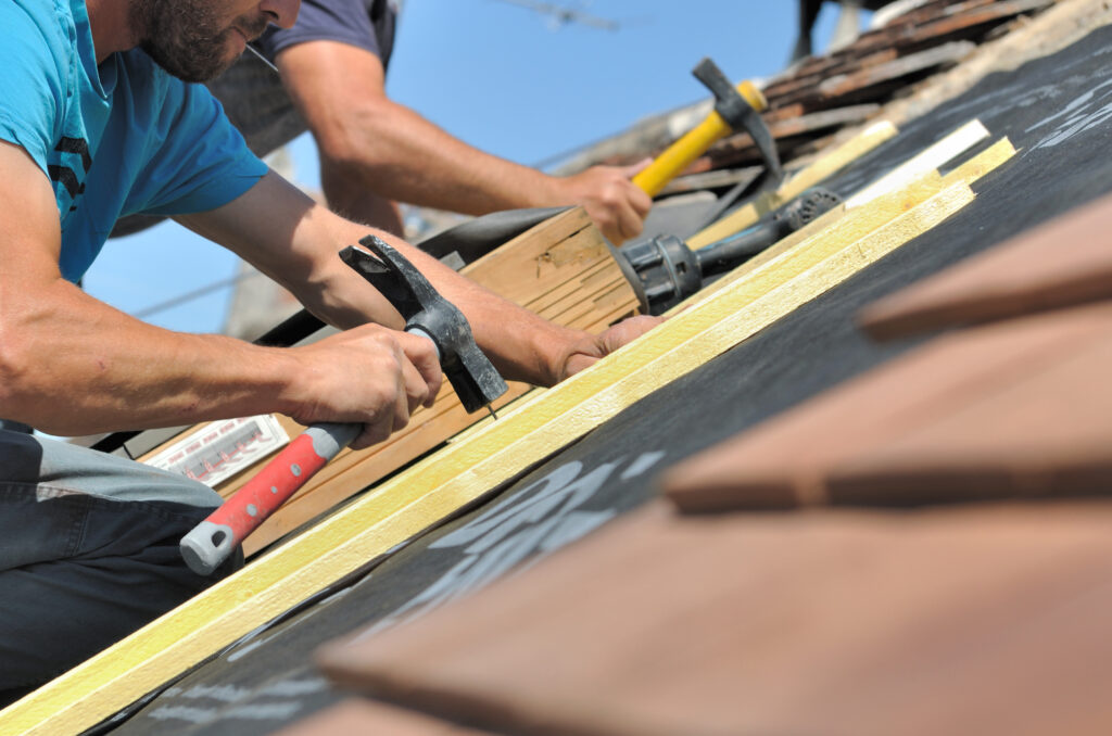 couvreurs clouant des lattes pour rénovation toiture